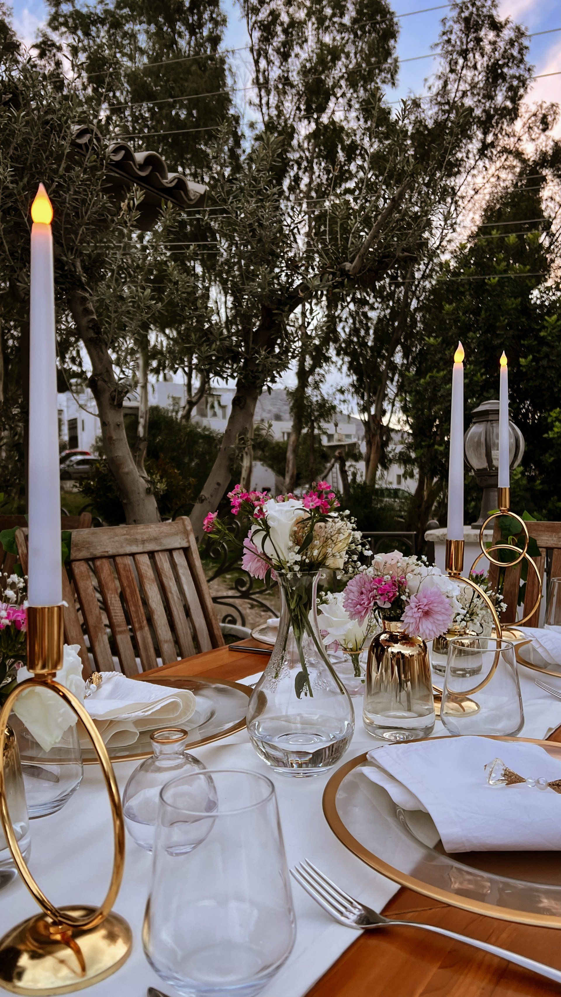 A table set for a wedding reception with candles and flowers on it.