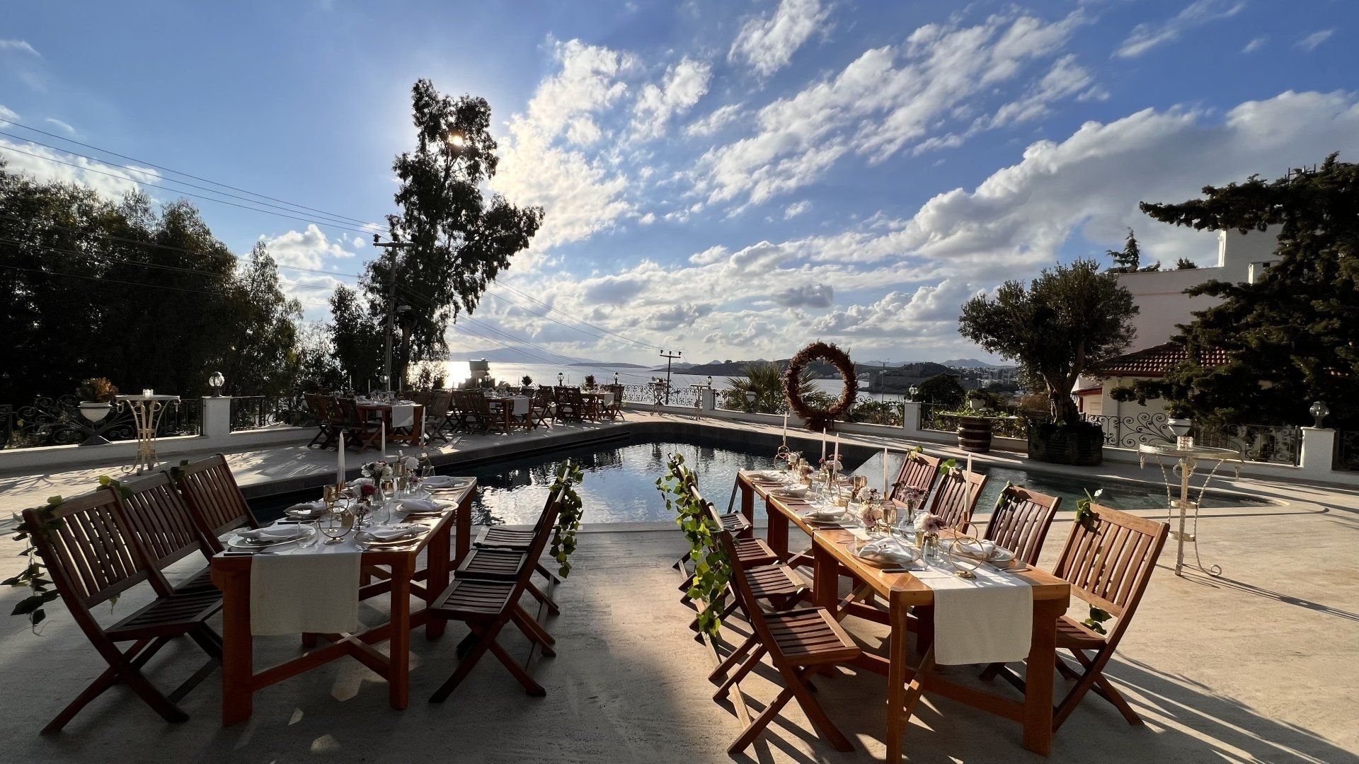 Tables and chairs are set up in front of a swimming pool