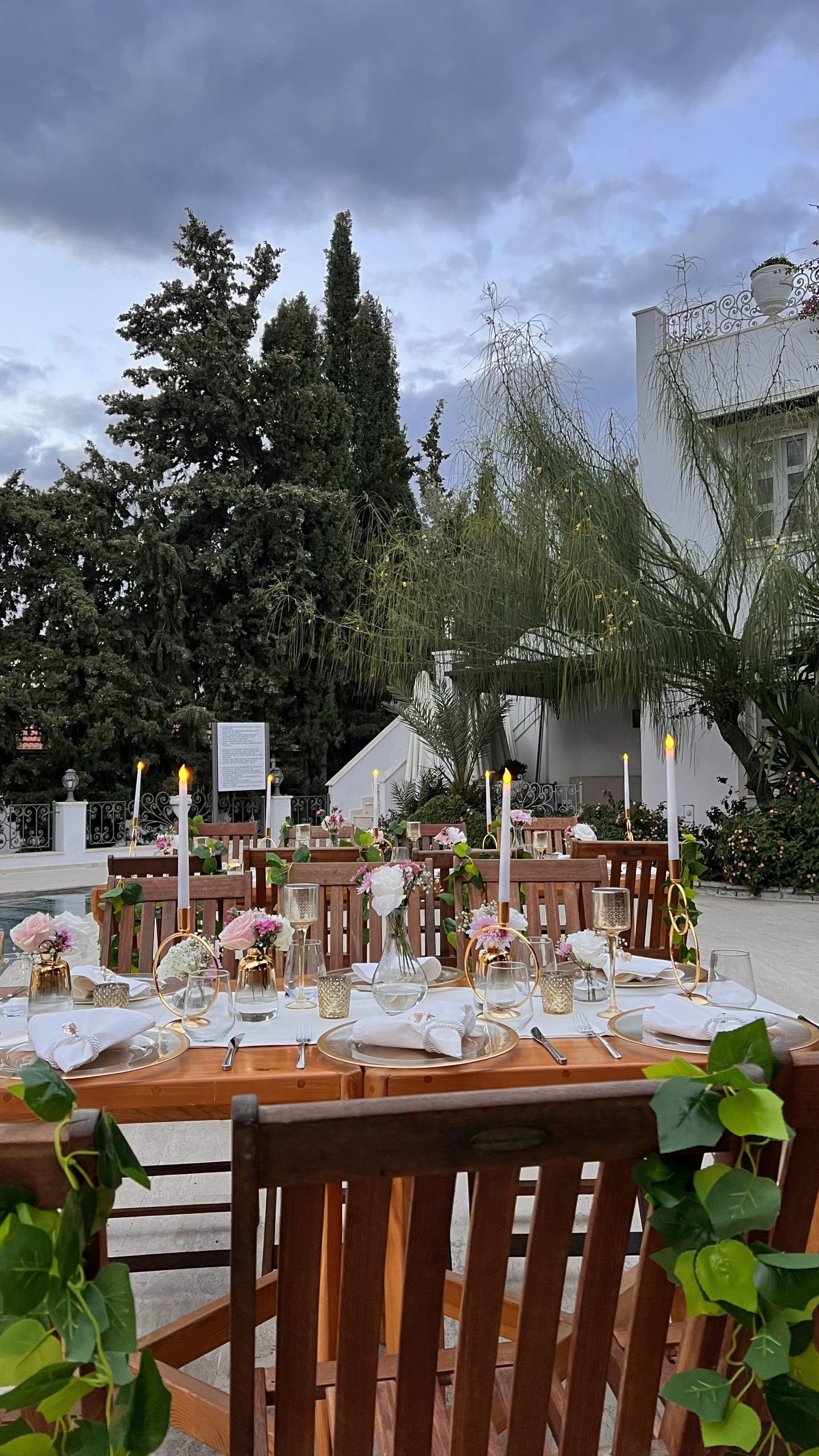 A table set for a wedding reception with candles and flowers on it.