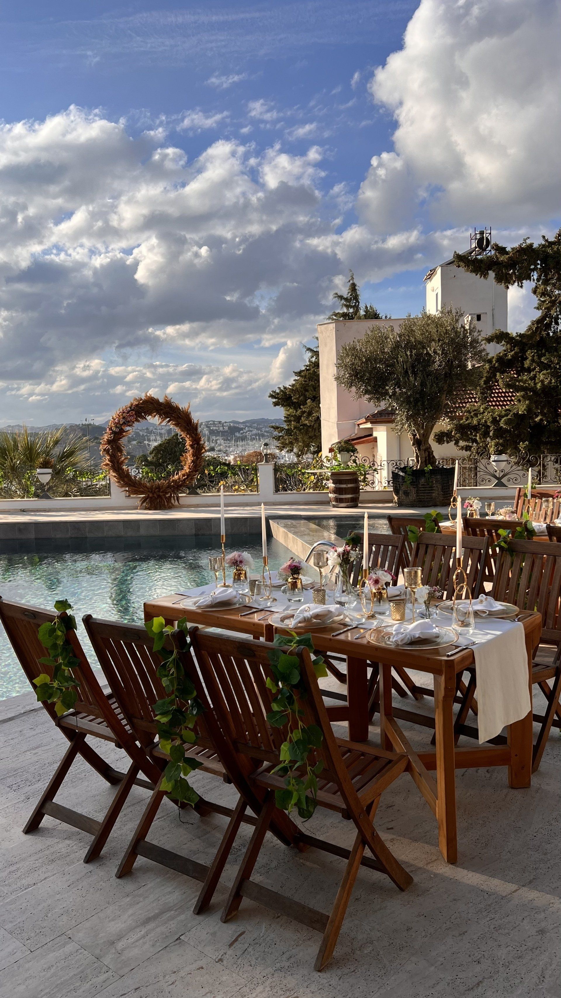 A table and chairs are set up in front of a swimming pool.
