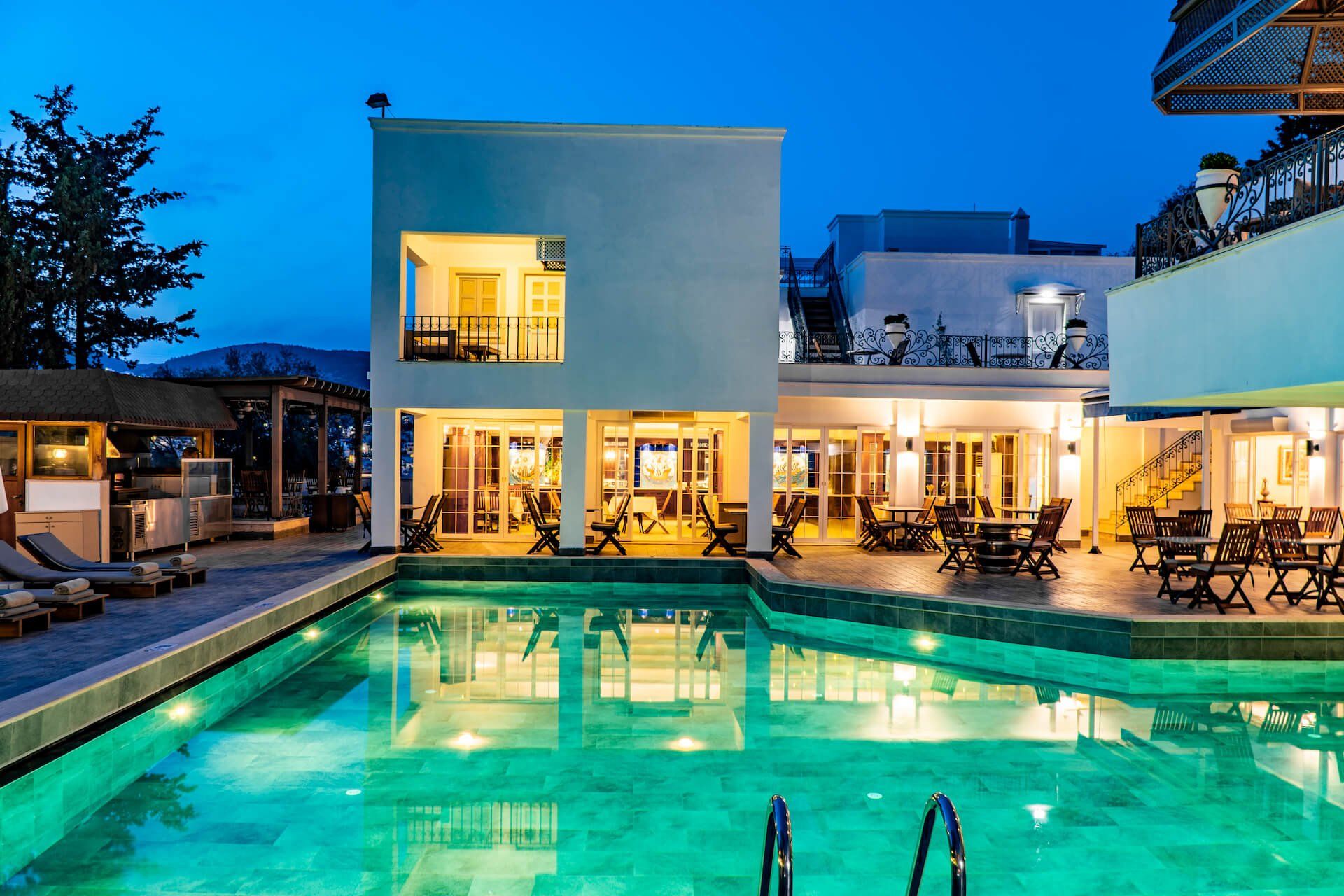 A large swimming pool is in front of a large white building.