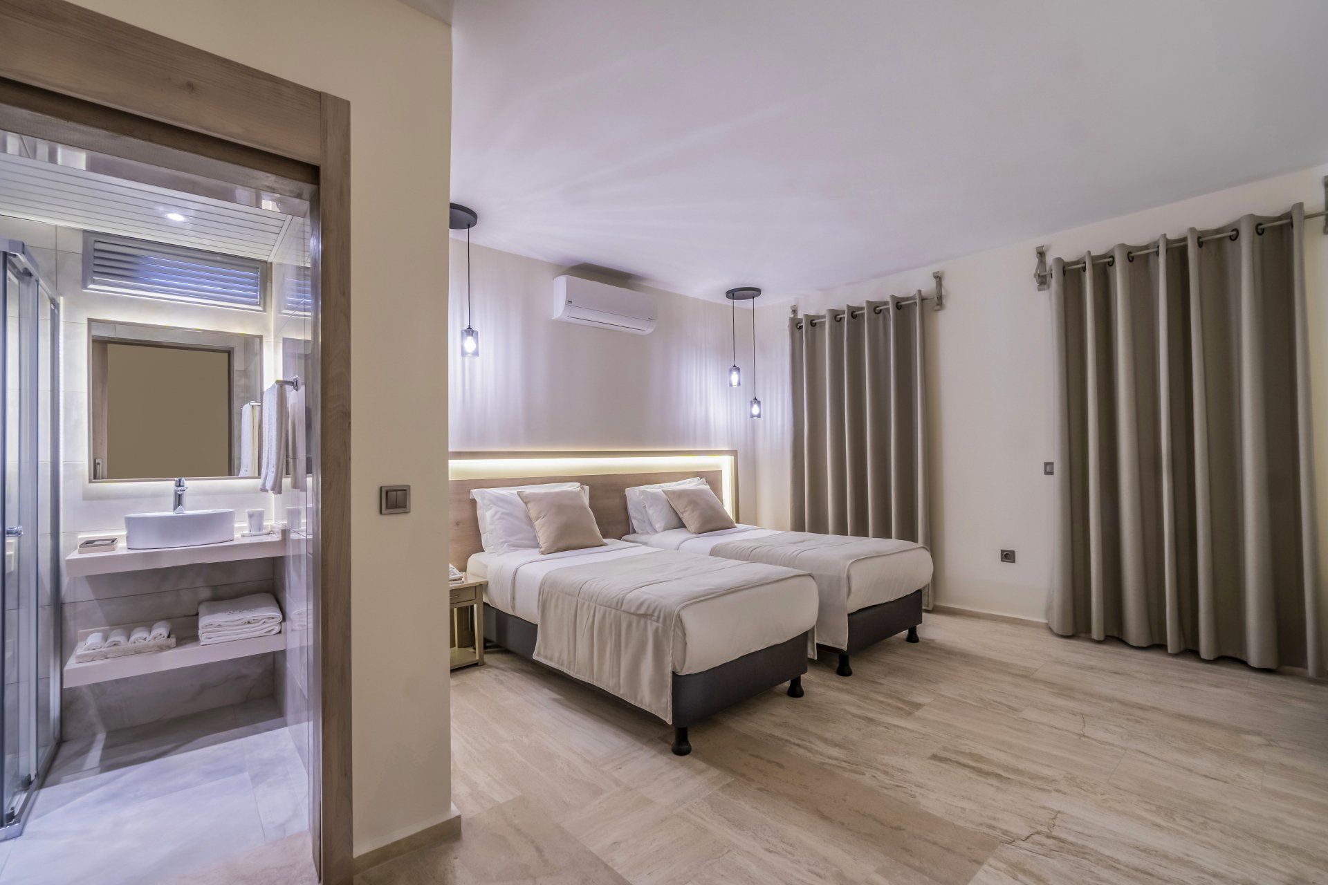 A hotel room with two beds and a bathroom.