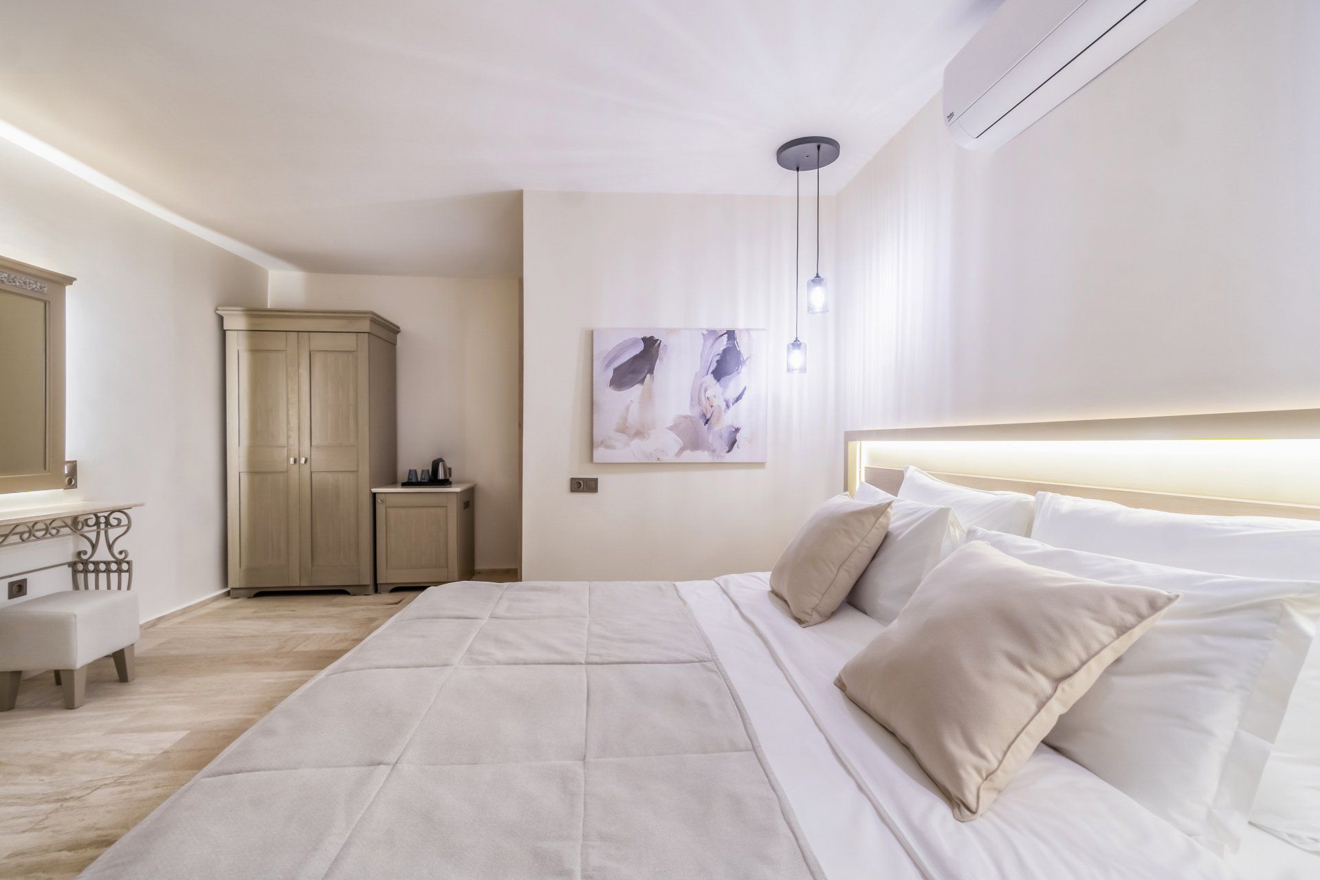 A bedroom with a large bed and a painting on the wall.