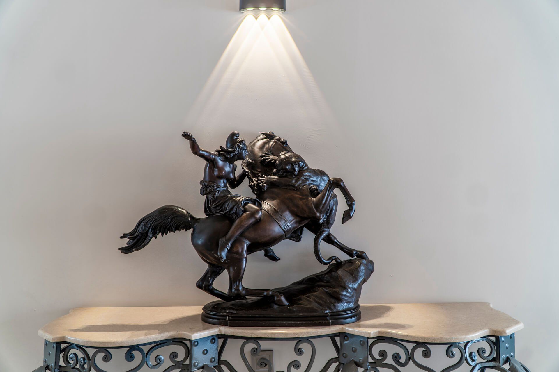 A bronze statue of a man riding a horse on a table.