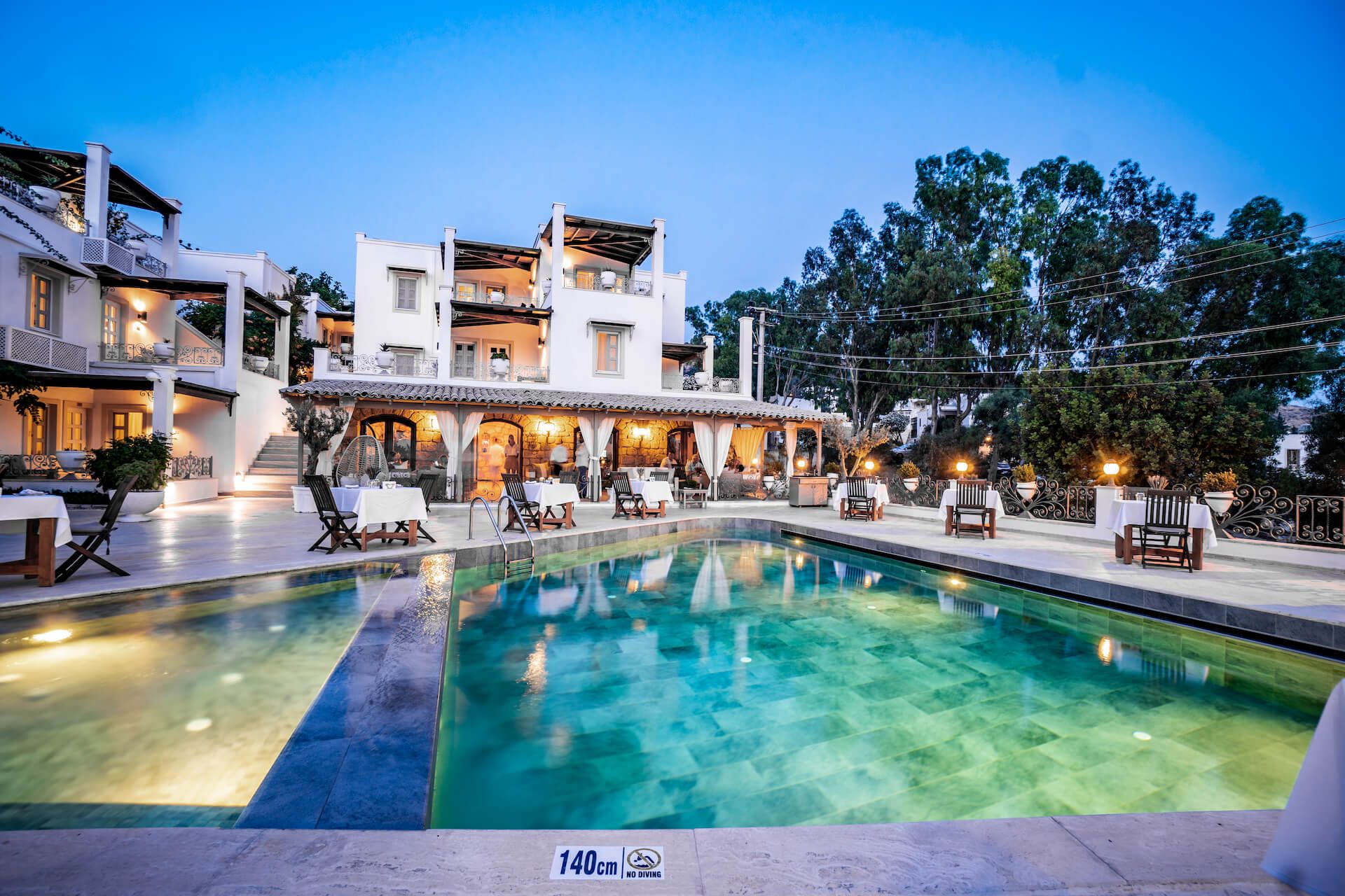 A large swimming pool is in front of a large building.