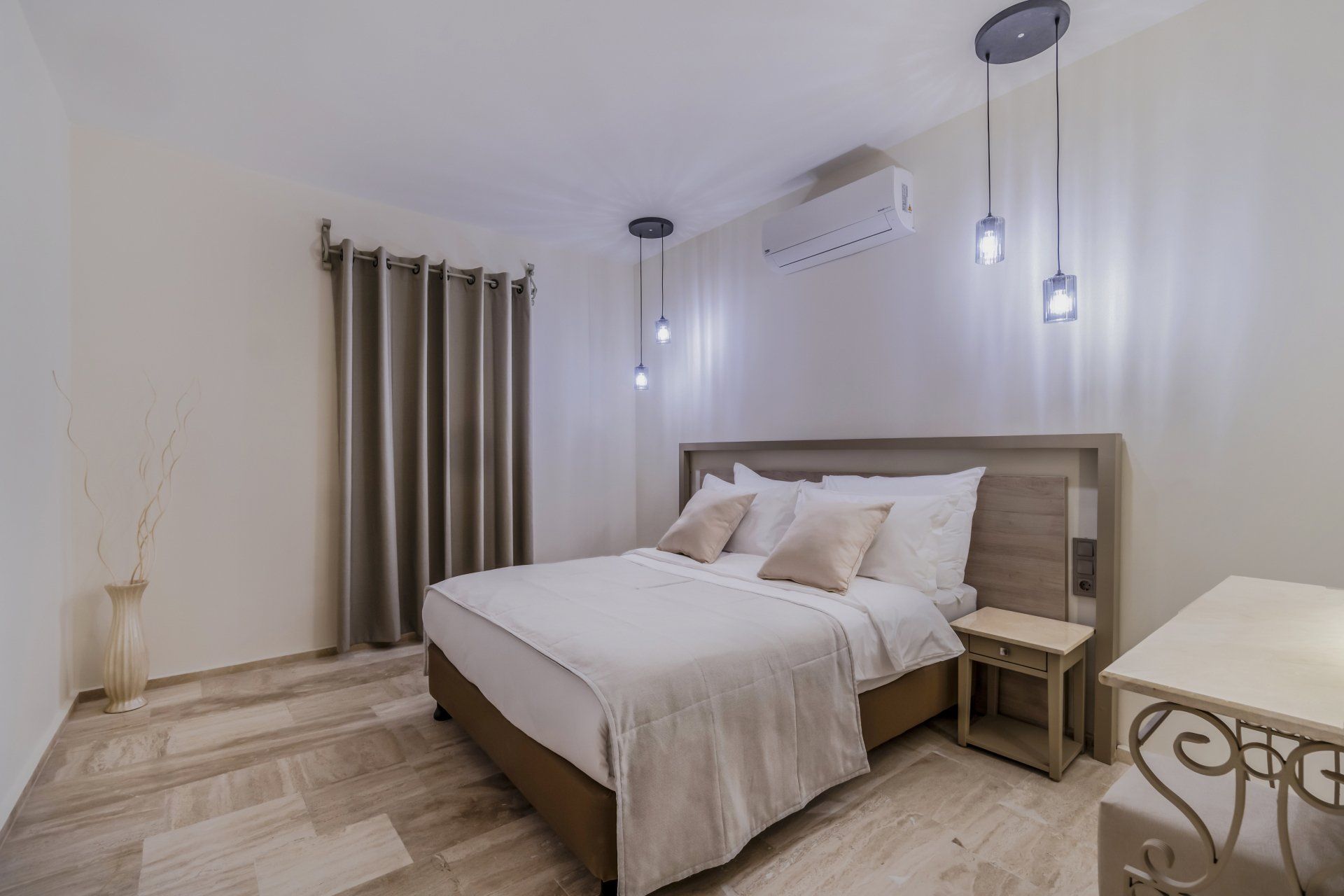 A hotel room with a king size bed and a nightstand.