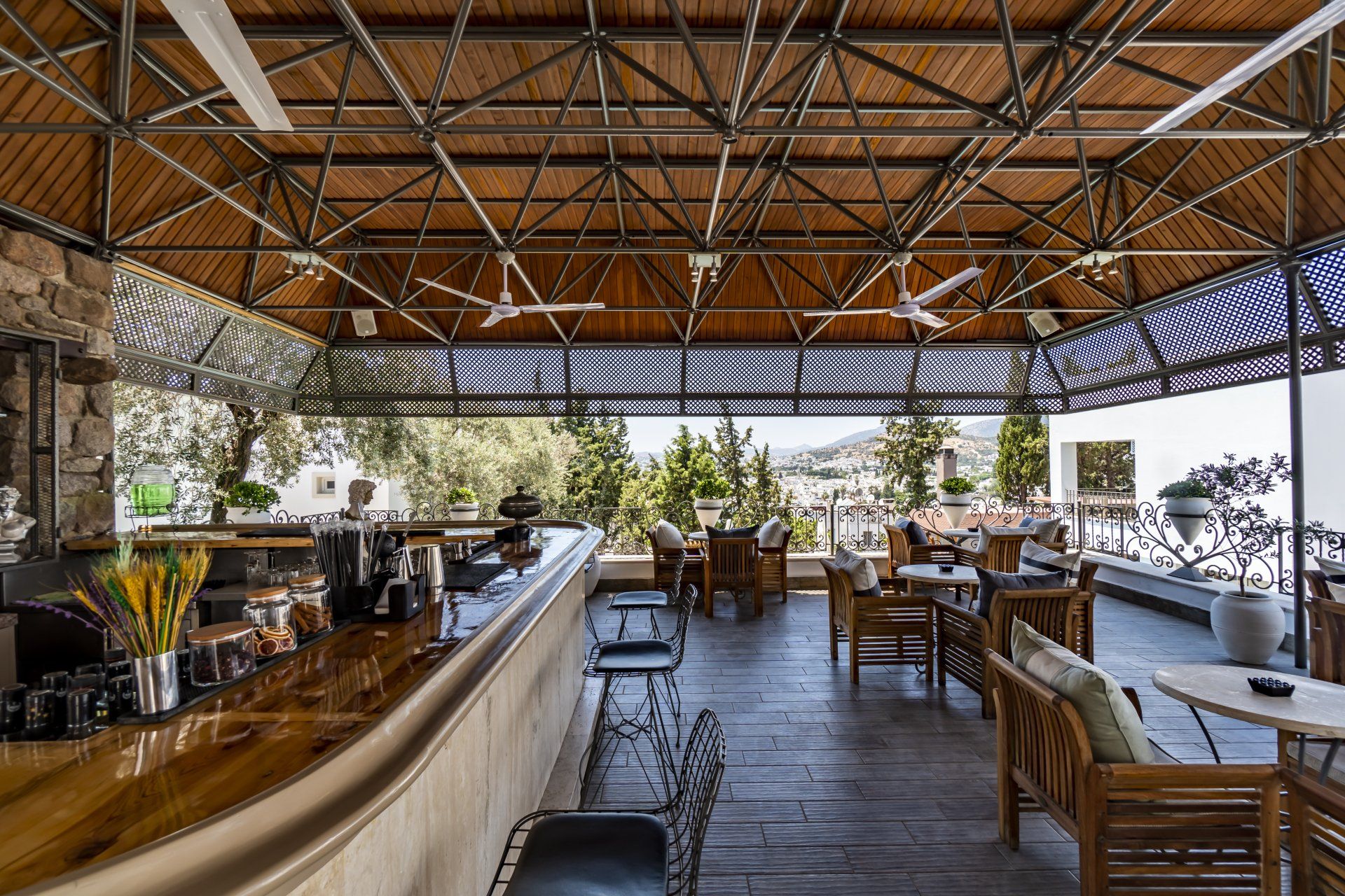 A restaurant with a bar and tables and chairs under a roof.
