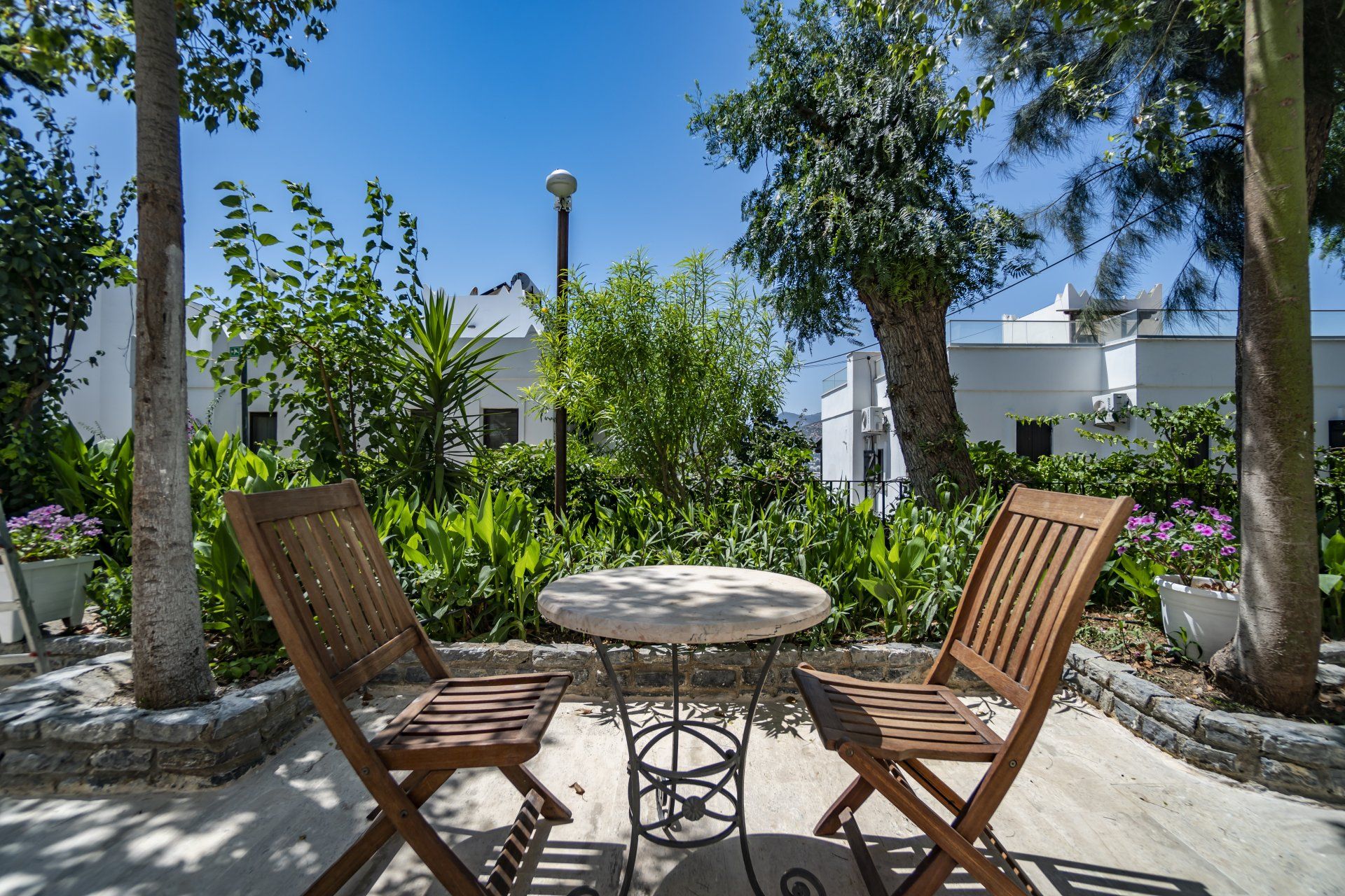 A table and chairs are sitting on a patio in a garden.