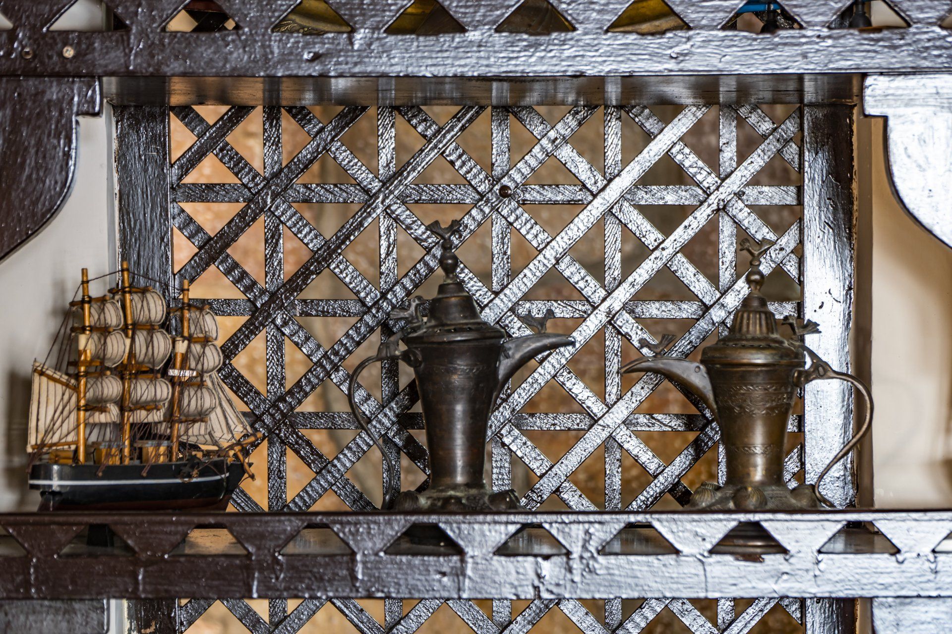 A wooden shelf with various items on it including a model ship