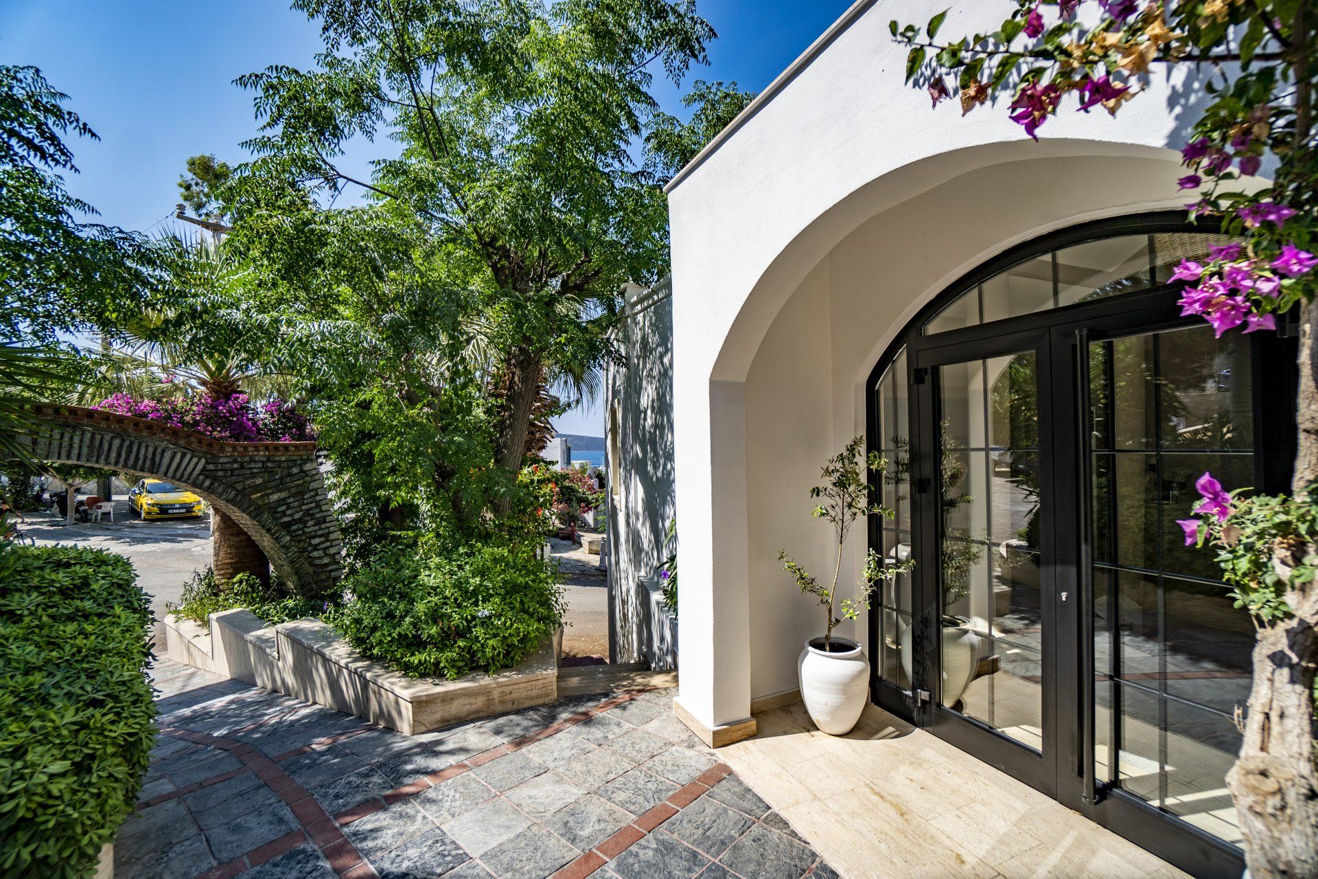A white building with purple flowers in front of it.