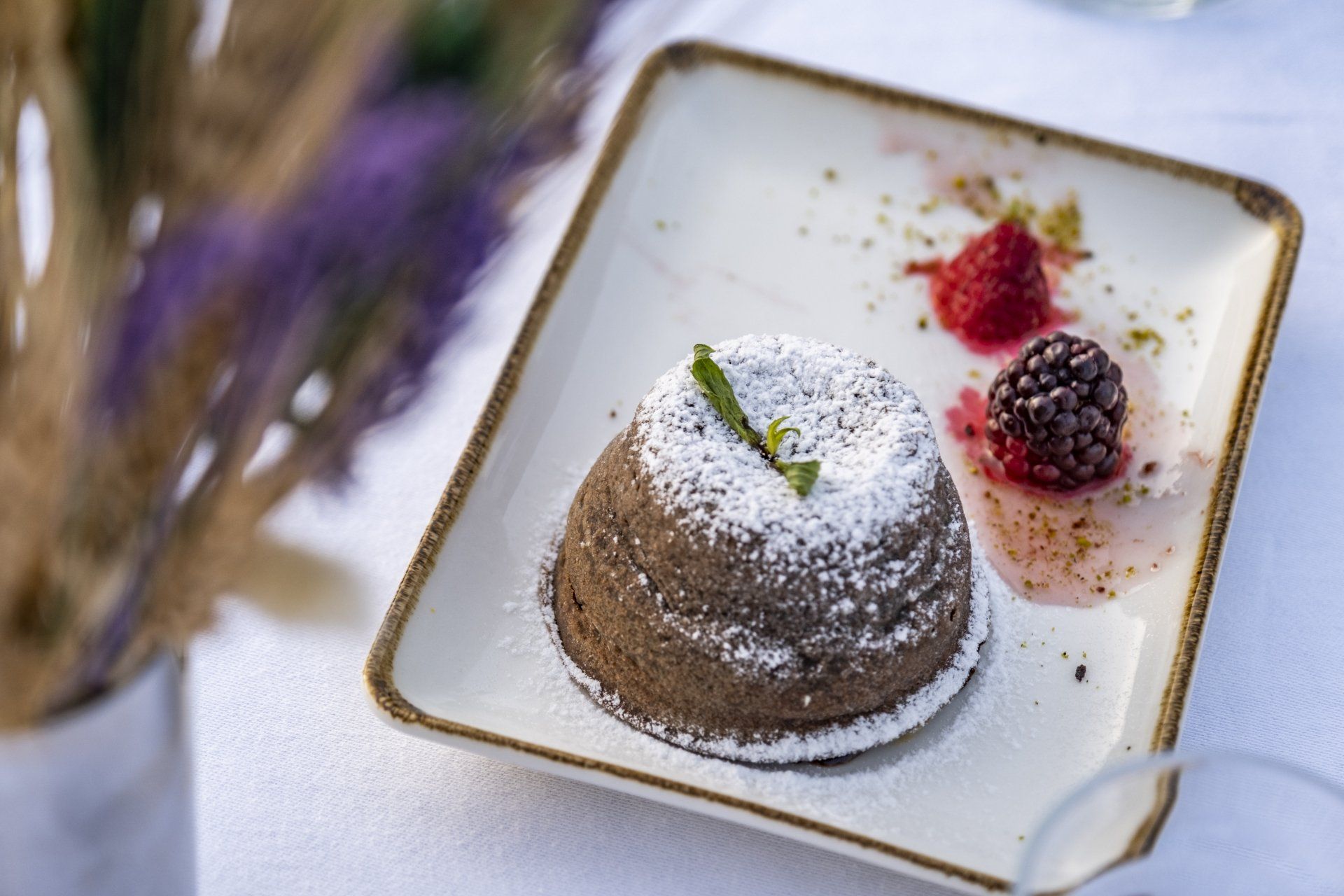 A white plate topped with a chocolate cake and berries.