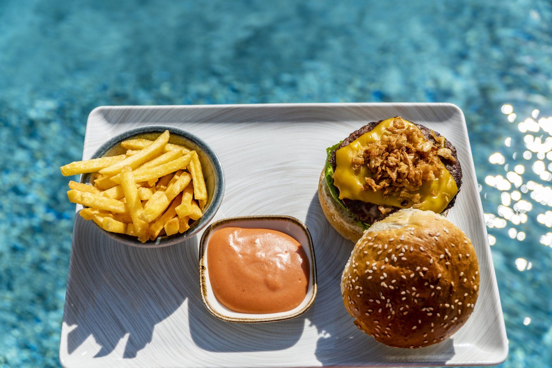 A white tray with a hamburger , french fries , and ketchup on it.