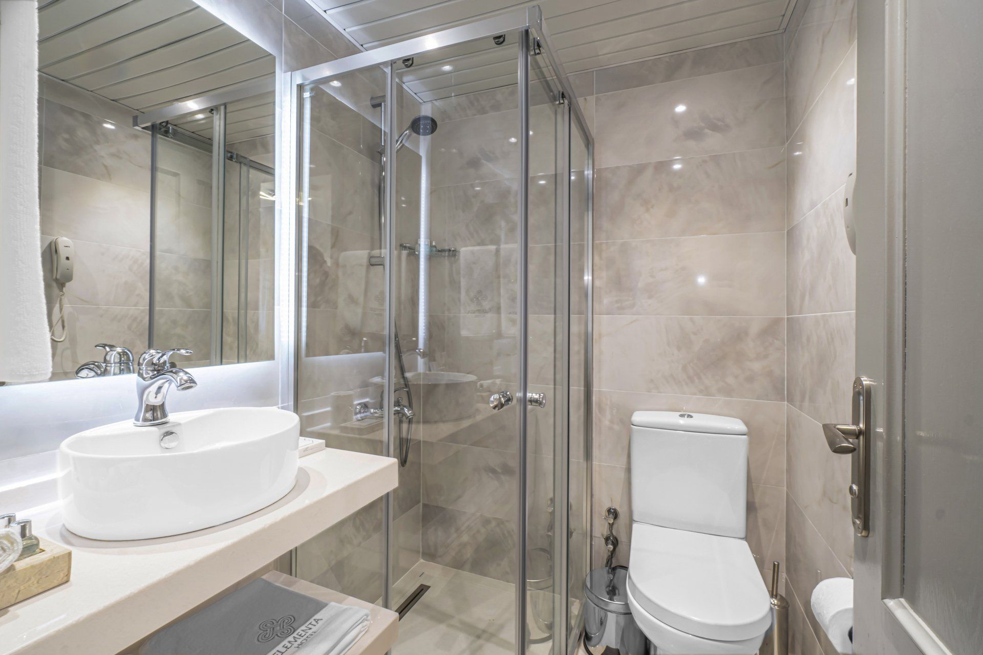 A bathroom with a toilet , sink and shower stall.