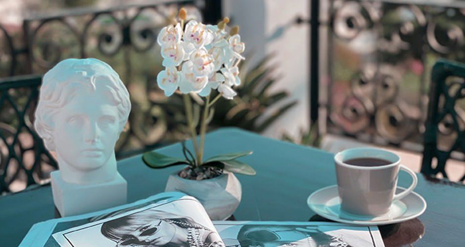 A table with a cup of coffee and a magazine on it.