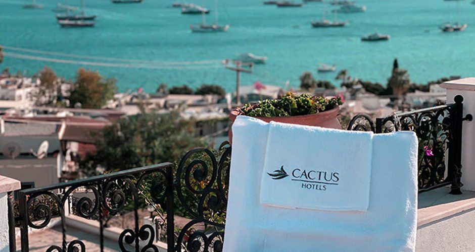 A chair with a towel on it is sitting on a balcony overlooking the ocean.