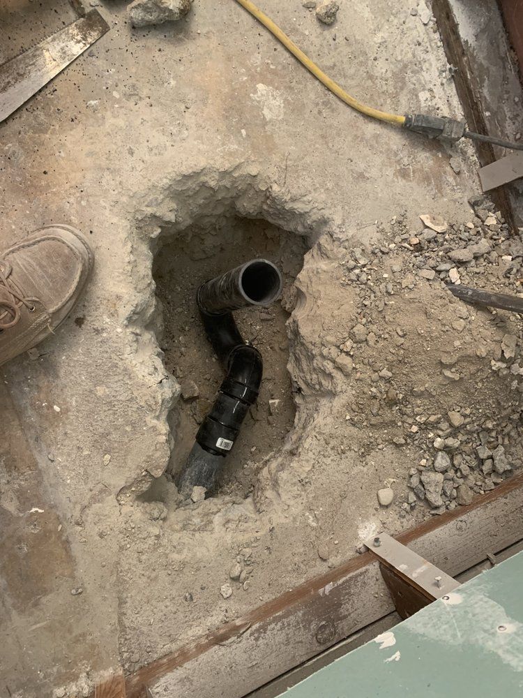A hole in the ground with a pipe in it.