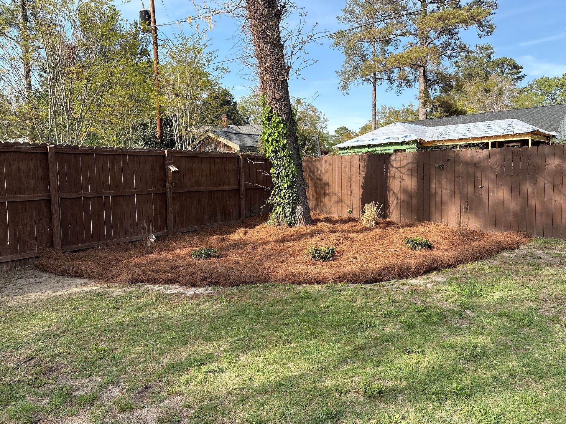 A man wearing a hard hat and goggles is standing in a room.