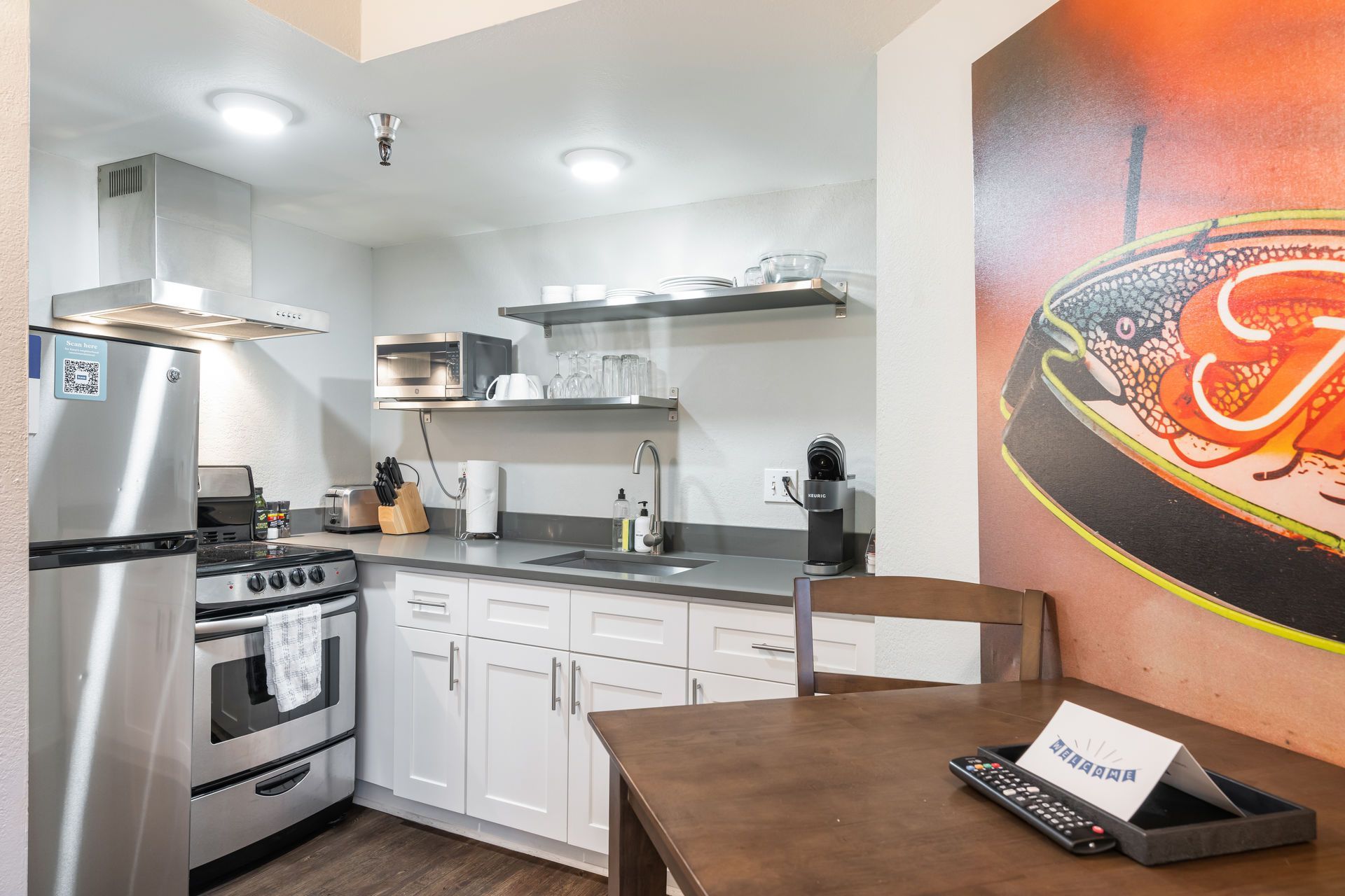 Small kitchen with stainless steel appliances, white cabinets, and a dining table.