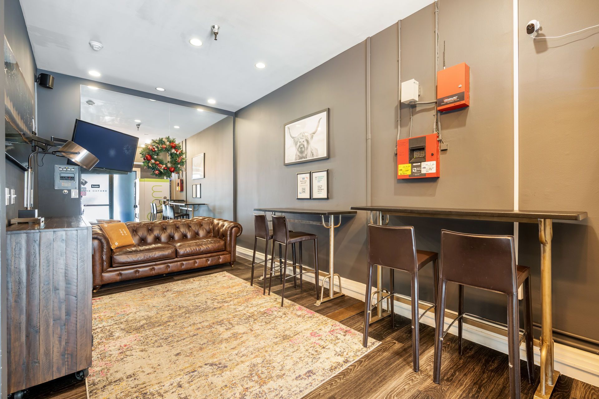 A small cafe interior with a leather sofa, bar seating, and industrial accents.