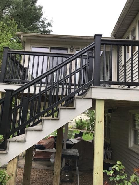 Stairs leading up to a house with a black railing