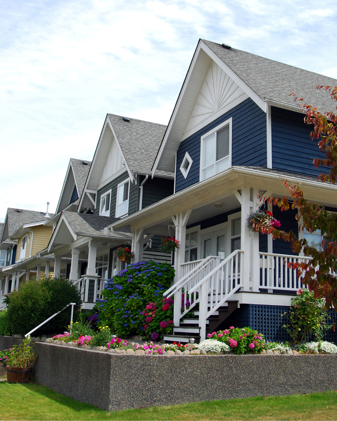 Row of colorful houses with white trim and porches.