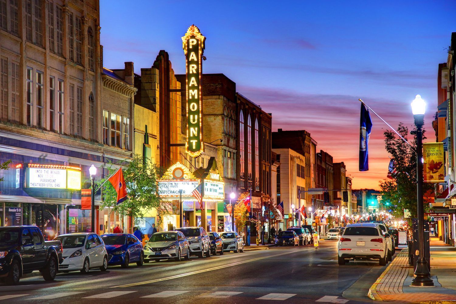 Image of State Street in Downtown Bristol showing The Paramount Sign lit up at night with other businesses