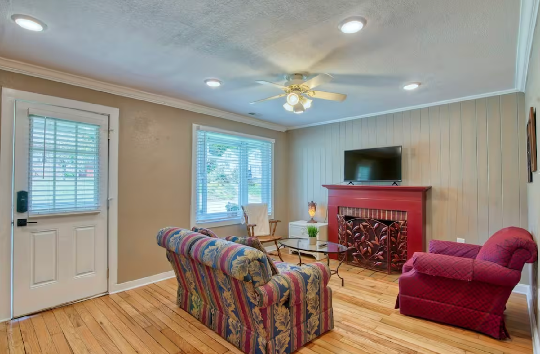 A bedroom with a bed and a ceiling fan