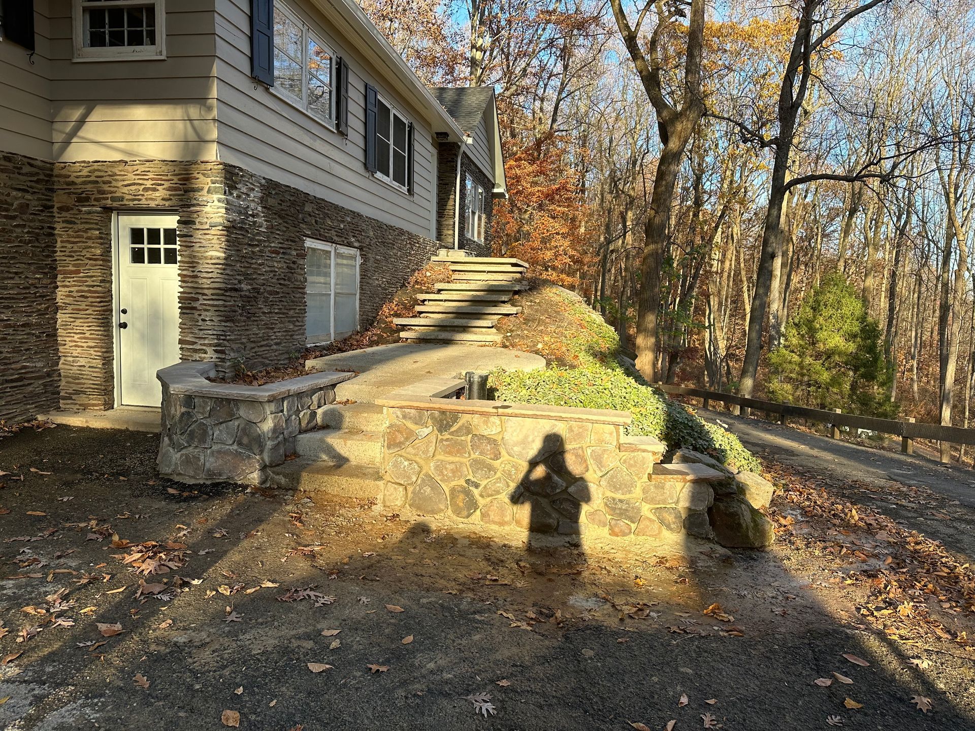 A hammer is sitting on top of a pile of bricks on a patio.