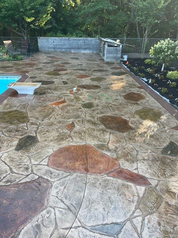 A broom is being used to level a concrete driveway.