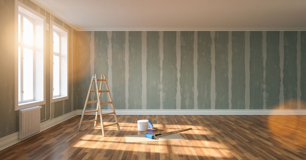 An empty room with a wooden floor and a ladder.