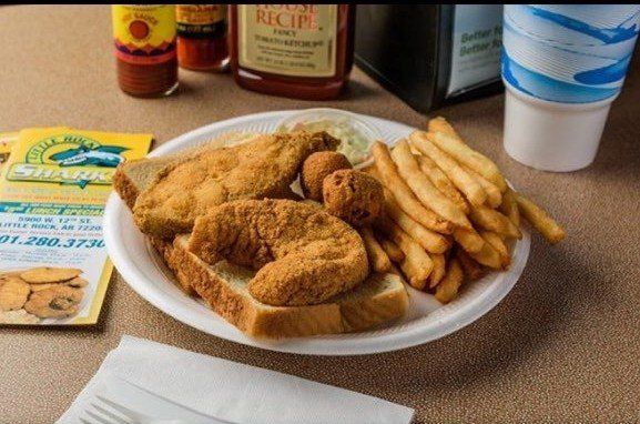 A plate of fried fish and french fries on a table