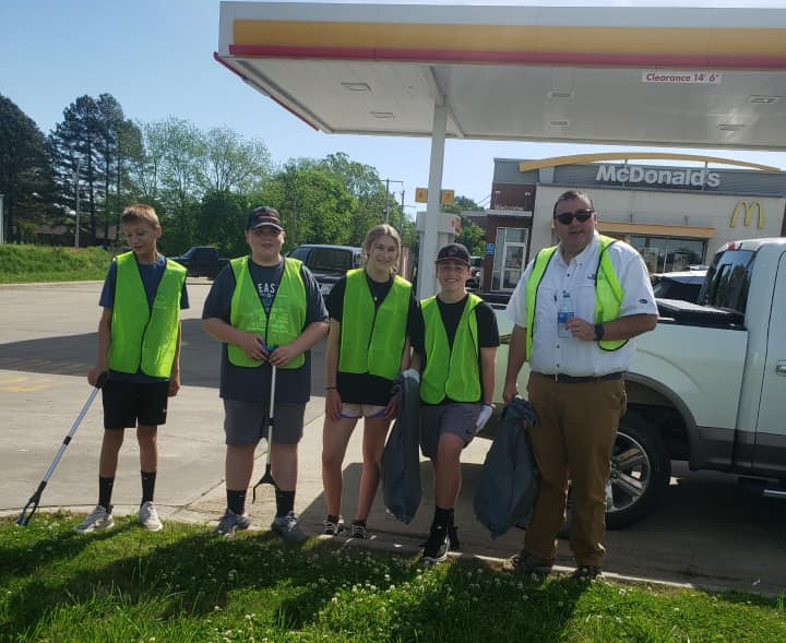 A group of people are standing in front of a mcdonald 's gas station.