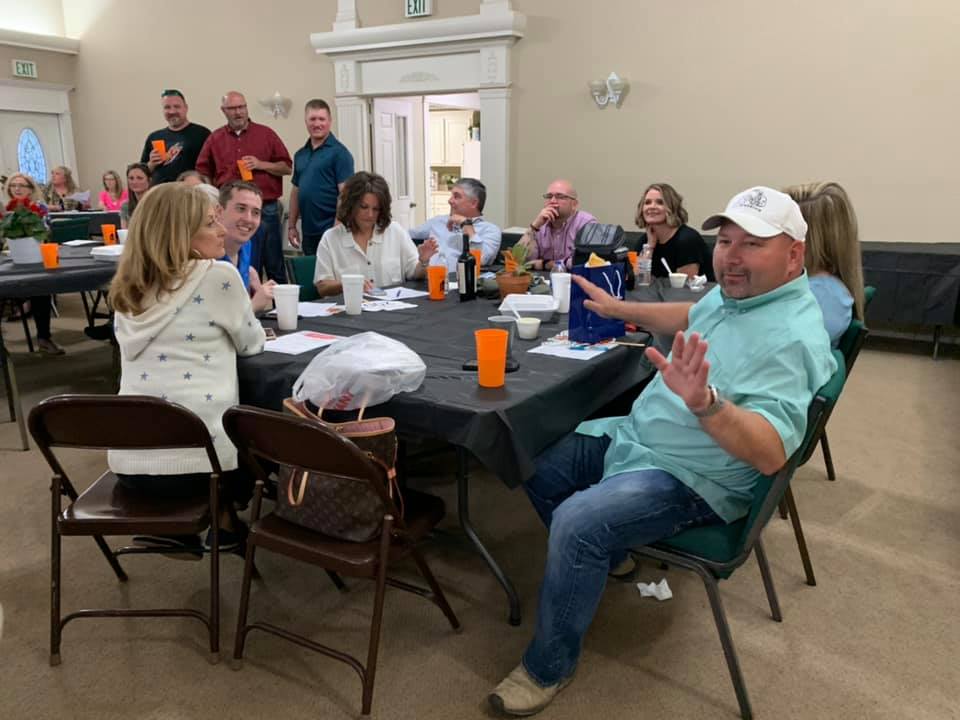 A group of people are sitting around a table in a room.