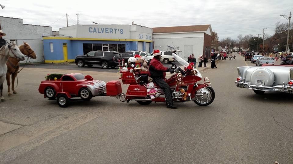 A man is riding a motorcycle with a trailer attached to it.