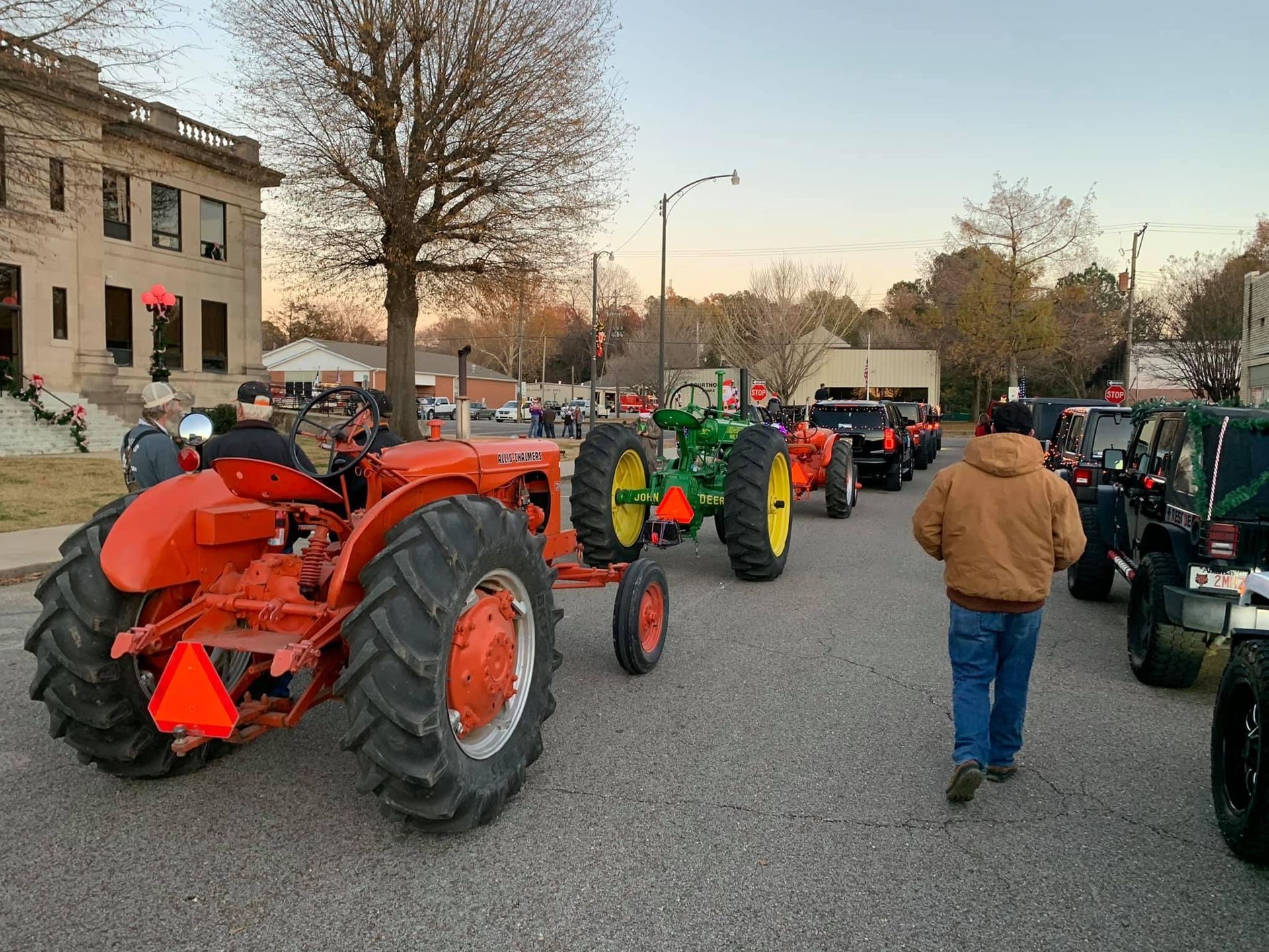 A group of tractors are parked on the side of the road.
