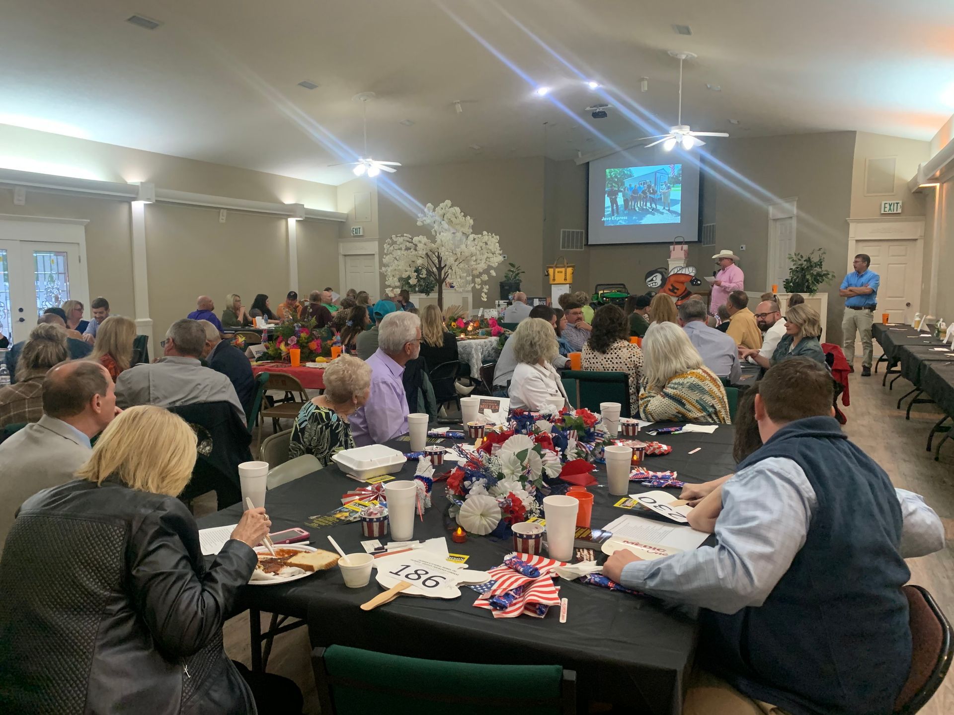 A large group of people are sitting at tables in a room.