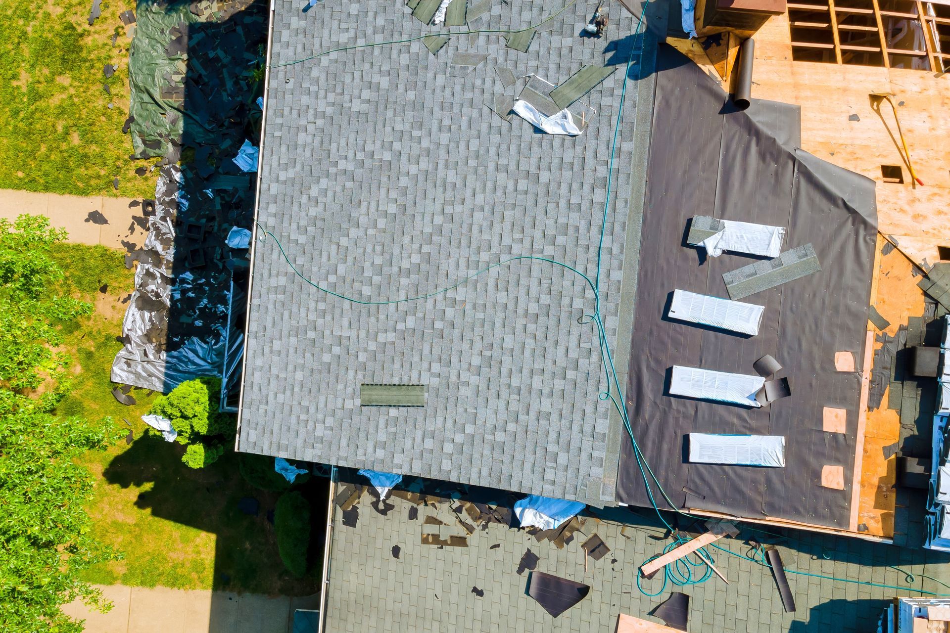 An aerial view of a house under construction with a roof being installed.