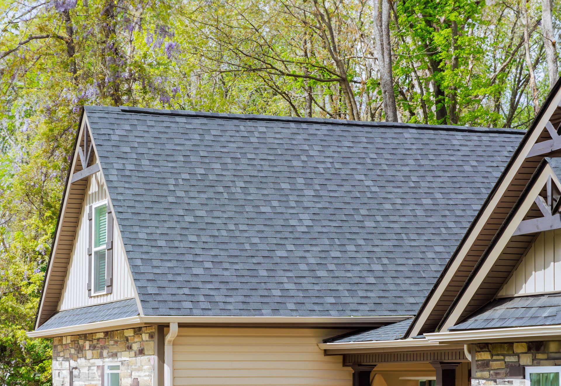 A house with a gray roof and trees in the background.