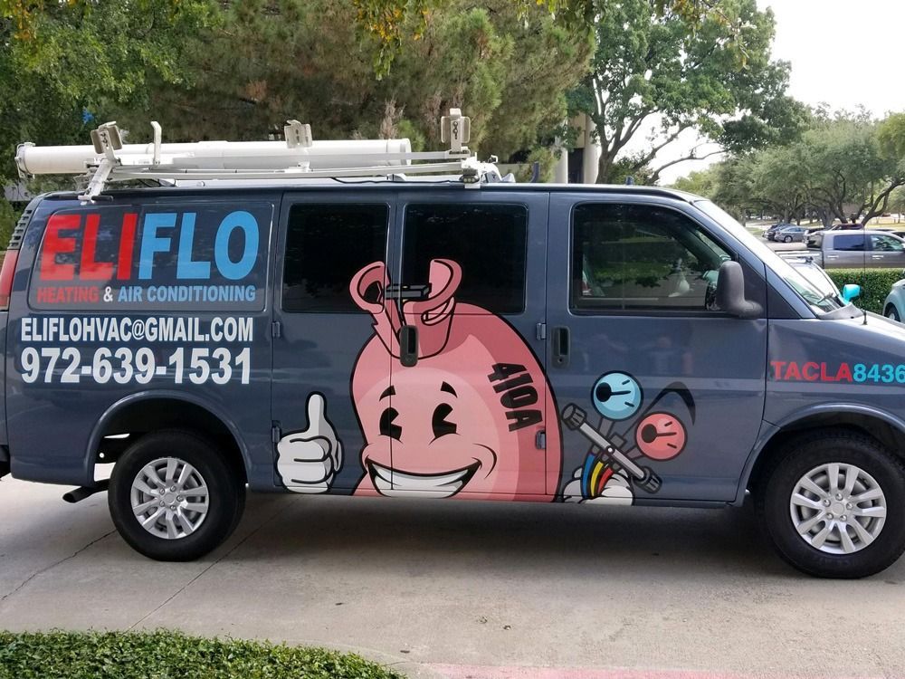 A row of air conditioners are sitting on the side of a brick building.