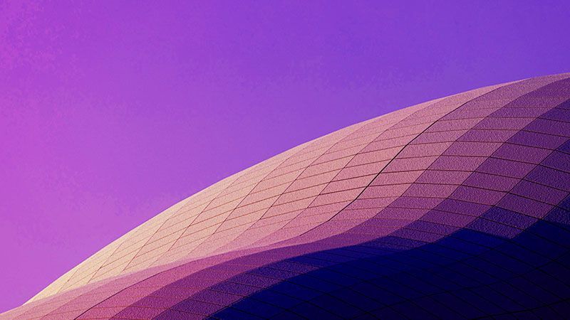 A smooth golf-ball top of a modern building against a neon sky