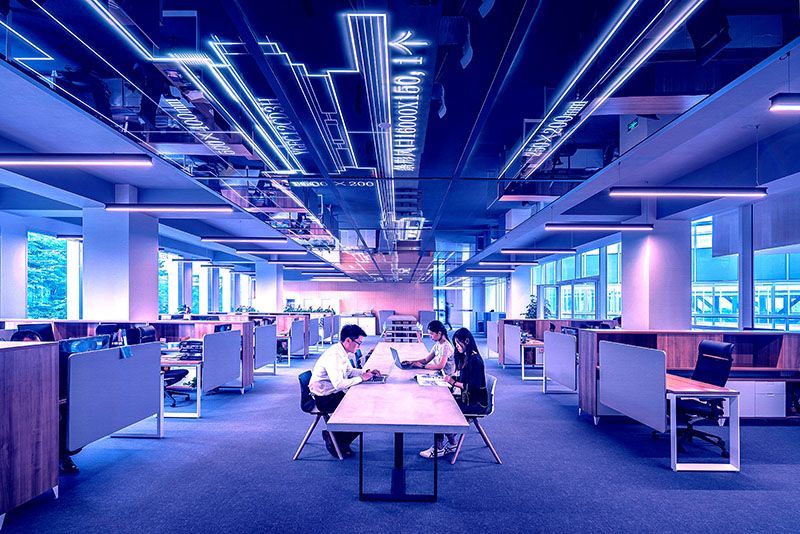long office with central table; there are several Asian students working on laptops