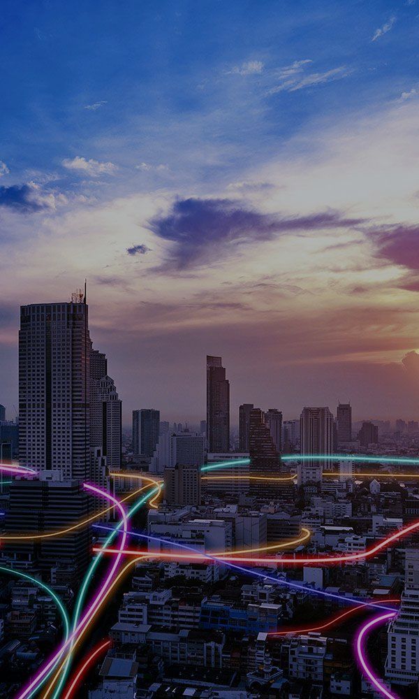 Neon lines snaking through a high-rise city at dawn