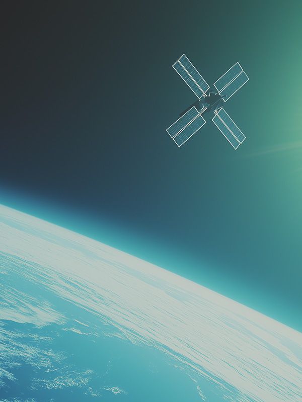 Satellite hovers over the earth in space. Sun glows in right.