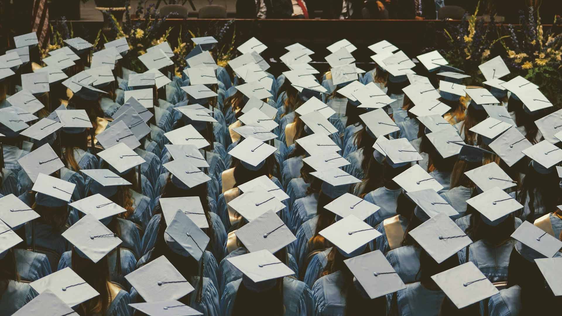 Aerial shot of graduation: a sea of light blue square hats with tassles
