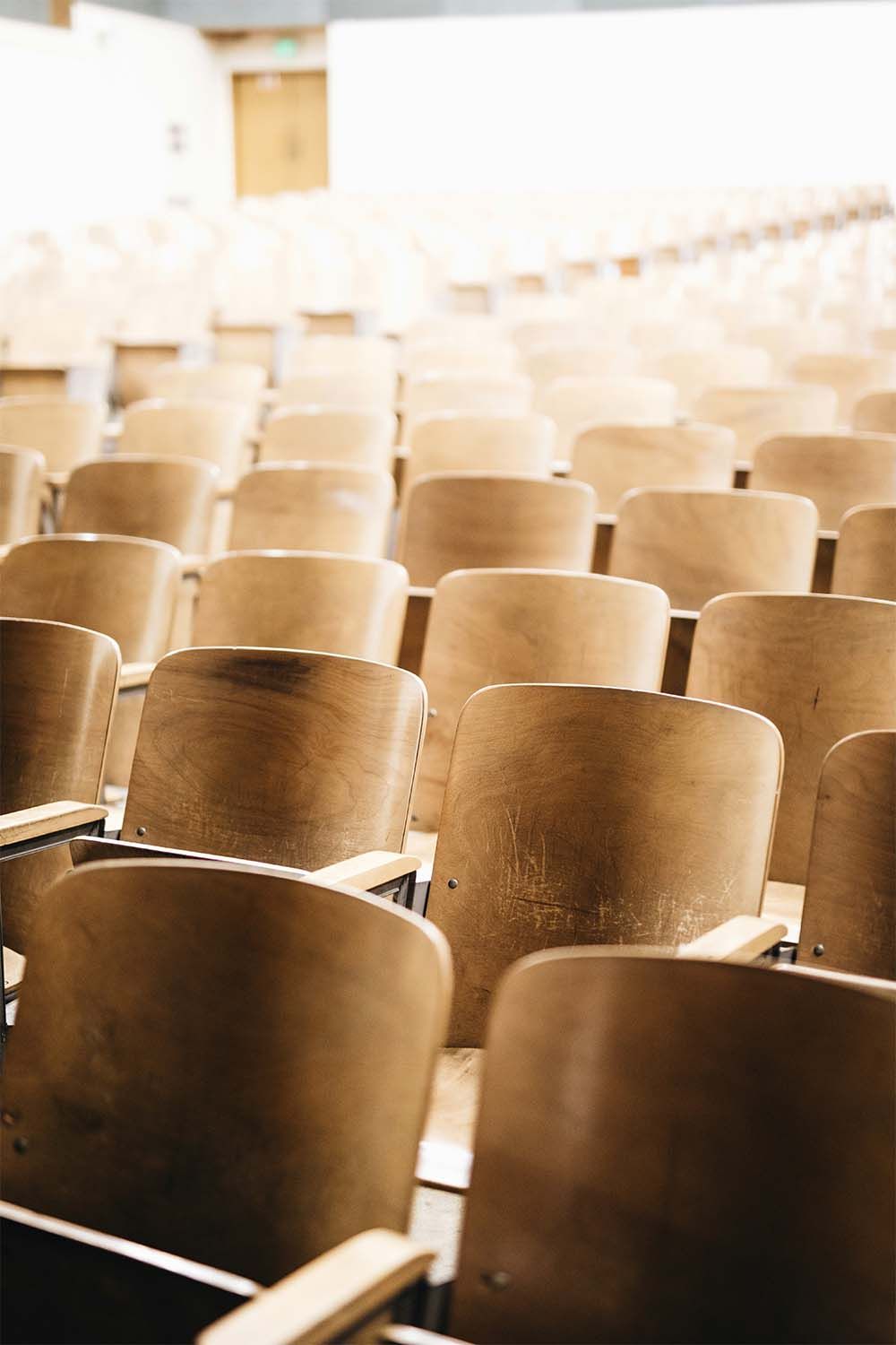 Rows of wooden chairs in an auditorium