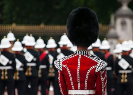 A member of the Queen's Guard in foreground with a line of horse guards in background