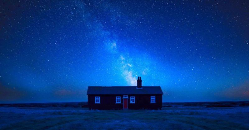 A lonely house in the countryside under a starry sky