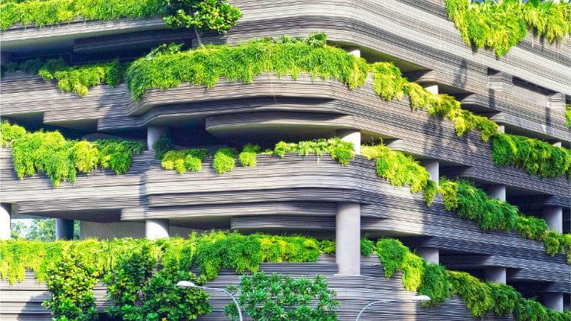 Futuristic building with greenery growing out of it.