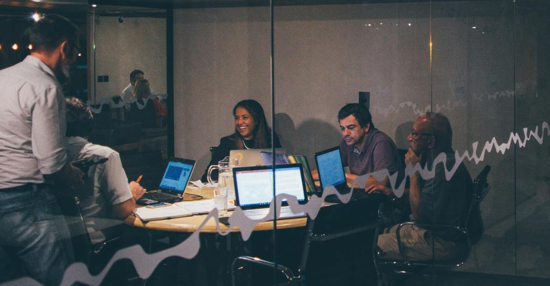 A group office workers working late over glowing laptops