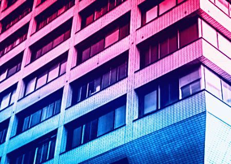 Close up of a concrete office building with a neon tint